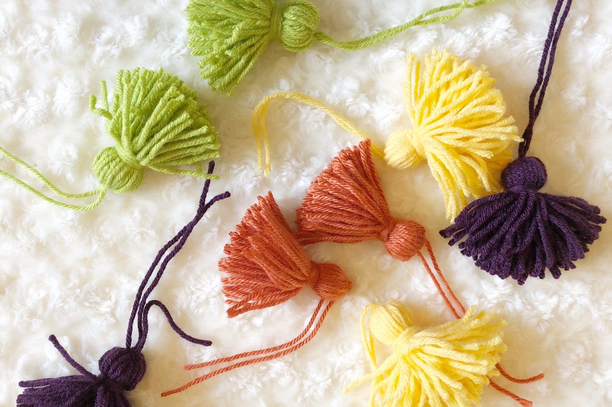 Green, yellow, orange, and purple DIY yarn tassels