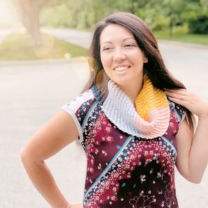 Multicolored crochet scarf with diagonally ribbed texture made with the Kelsi Scarf pattern shown in use.