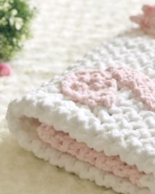 Pink and white swan crochet blanket folded